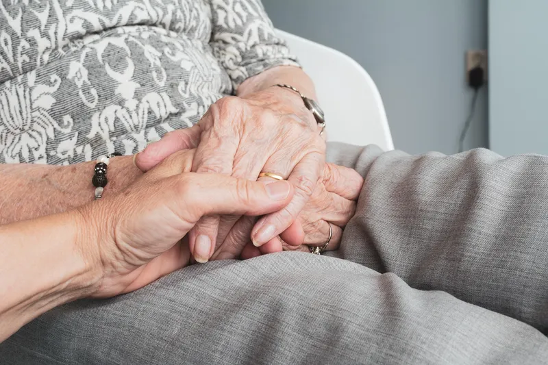 An elderly couple holding hands